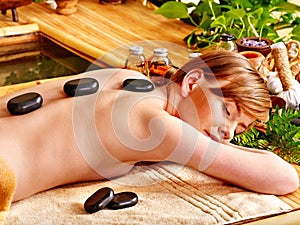 Woman getting stone therapy massage .