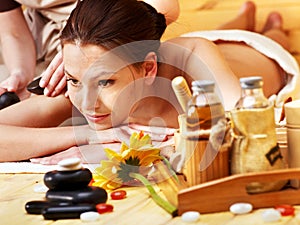 Woman getting stone therapy massage .