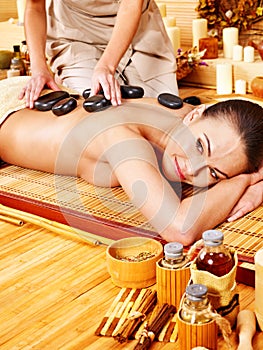 Woman getting stone therapy massage .