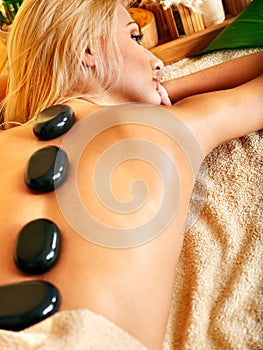 Woman getting stone therapy massage .