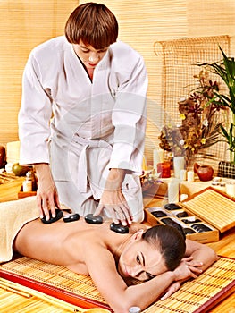 Woman getting stone therapy massage .