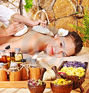 Woman getting thai herbal compress massage . photo
