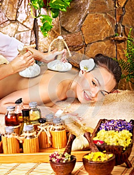 Woman getting thai herbal compress massage .