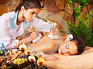 Woman getting thai herbal compress massage . photo