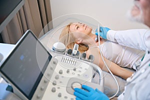 Woman getting thyroid ultrasound exam at clinic