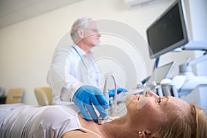 Woman getting thyroid ultrasound exam in hospital