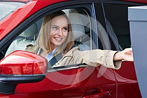 Woman getting ticket from parking meter in underground parking