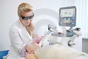 Woman getting treatment with aesthetic dermatology device