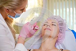 Woman getting treatment with injectable hyaluronic acid dermal filler photo