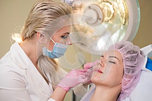 Woman getting treatment with injectable hyaluronic acid dermal filler photo