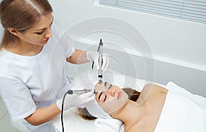 Woman getting ultrasound face beauty treatment in medical spa center