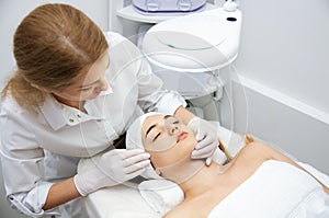 Woman getting ultrasound face beauty treatment in medical spa center