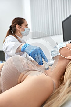 woman getting ultrasound of a thyroid from doctor