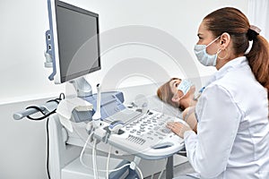 woman getting ultrasound of a thyroid from doctor