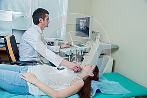 Woman getting ultrasound of a thyroid from doctor