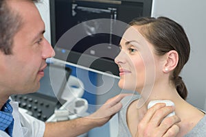 Woman getting ultrasound thyroid from doctor