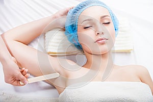 Woman getting waxing armpit by beautician