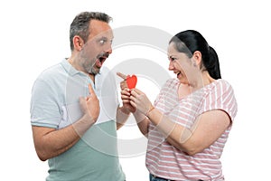 Woman gifting red heart to man