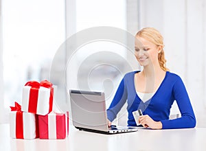Woman with gifts, laptop computer and credit card
