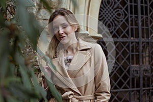 Woman, girl in beige coat looking up thoughtful