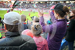 Woman, girl and boy standing applause among fans photo