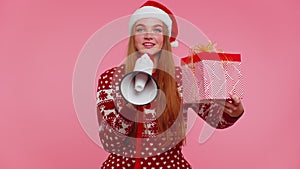 Woman girl in Christmas sweater with gift box scream in megaphone announces discounts sale shopping
