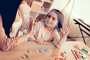 Woman and Girl with Colored Toy Numbers on Table.