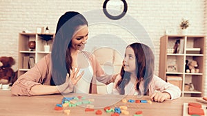 Woman and Girl with Colored Toy Numbers on Table