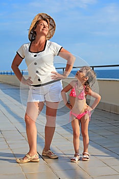 Woman and girl do morning exercise on veranda