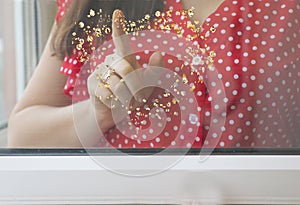 a woman girl draws a heart on a window pane