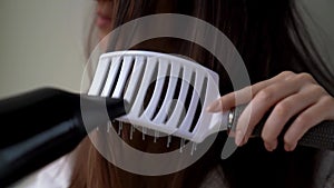 Woman girl is drying hair after washing, doing hairstyle.