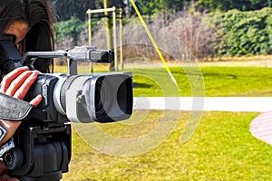 Woman girl filming in the park with a professional camera