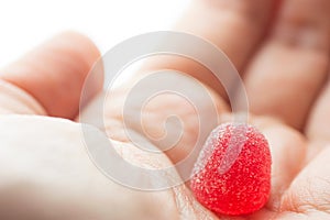 Woman girl holds in hand red strawberry jelly gummy candy on white background. Kids birthday party Halloween sweet treats