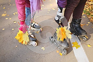 Woman and girl leaned yellow maple leaves to the