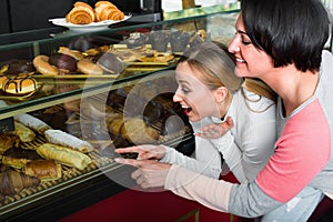 Woman and girl looking into the pastry shop window