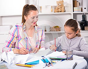 Woman and girl making airplanes of pape