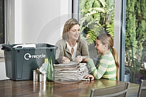 Woman And Girl Preparing Waste Paper For Recycling photo