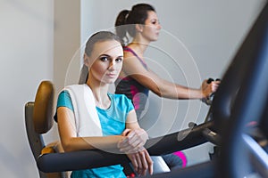 Woman girl resting at the gym on a cross trainer