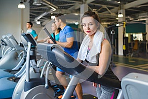 Woman girl resting at the gym on a cross trainer