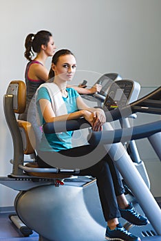 Woman girl resting at the gym on a cross trainer