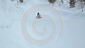 Woman and Girl Riding Fast on a Snow Tubing