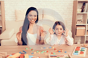 Woman and Girl Sitting with Toy Numbers in Hands.