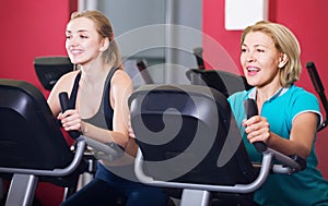 Woman and girl training on exercise bikes