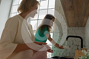 woman and girt wash dishes