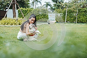 Woman gives pug a kiss outdoors