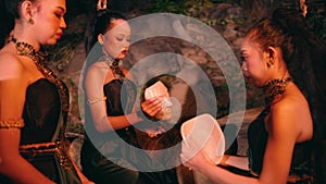 A woman giving a bamboo mask to her friends before the dance performance starts and they are getting ready together backstage