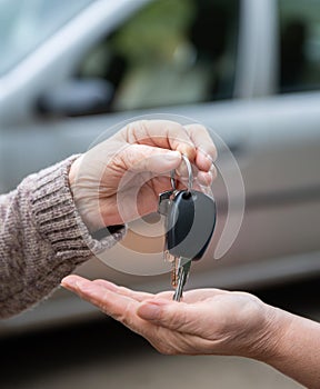 Woman giving car keys to another woman