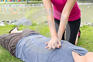 Woman giving cardiopulmonary resuscitation CPR to a man at pub