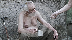 Woman giving coin to beggar