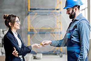 Woman giving cryptocurrency to a builder